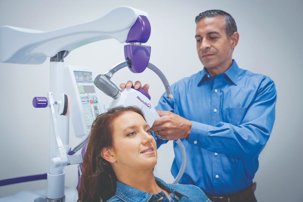 A doctor positioning a NeuroStar TMS device on a patient, illustrating what is the success rate of TMS therapy