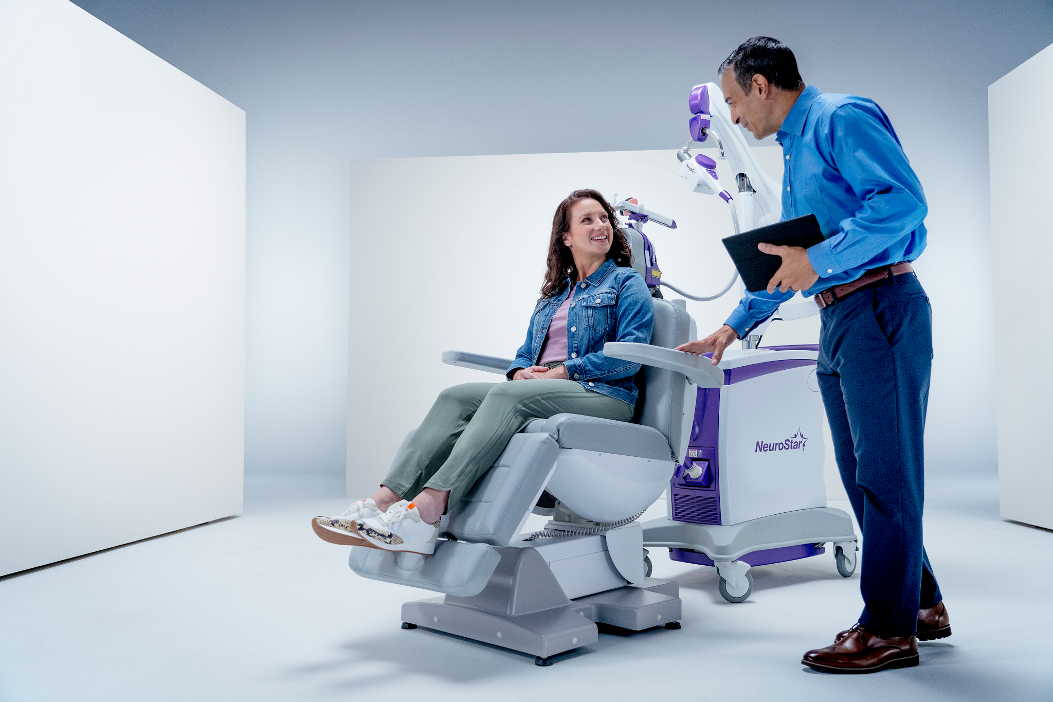 Doctor reviewing a clinical treatment plan and medical notes with a seated patient.